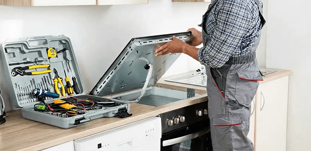 Handyman repairing a cooktop and checking wiring connections in Philadelphia, PA