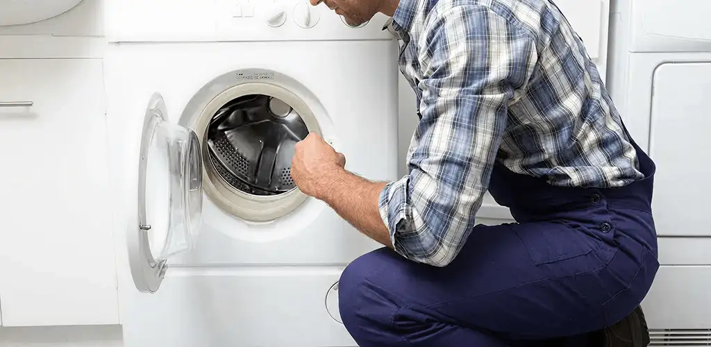 Handyman inspecting a dryer drum and internal parts for repair in Philadelphia, PA