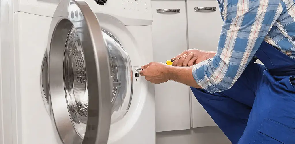 Handyman repairing a clothes dryer and checking electrical connections in Philadelphia, PA