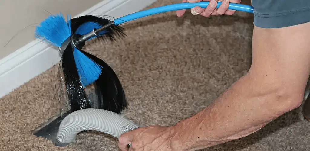 Dryer vent cleaning technician brushing lint from a vent line in Philadelphia, PA