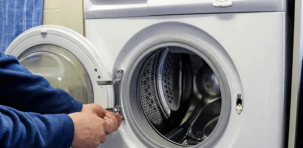Washing machine repair handyman checking a front-load washer door and latch in Philadelphia, PA