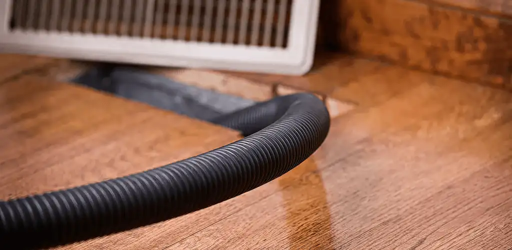 Air duct cleaning hose inserted into a floor vent for ductwork cleaning in Philadelphia, PA