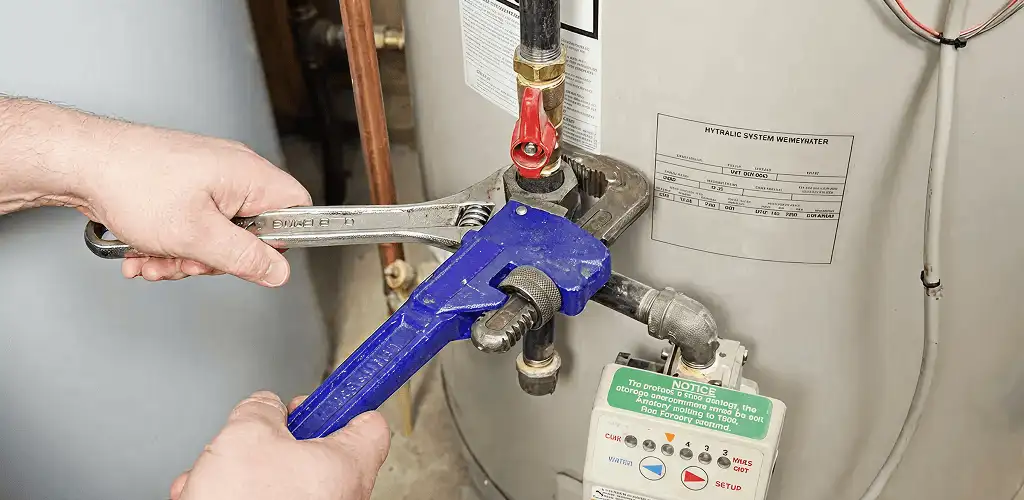 Water heater repair technician tightening the shutoff valve and supply line in Philadelphia, PA